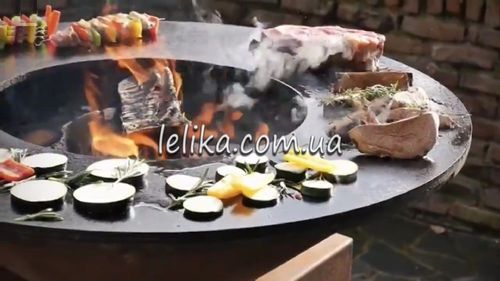 круглий мангал барбекю з плоским жарочним диском на тумбі 